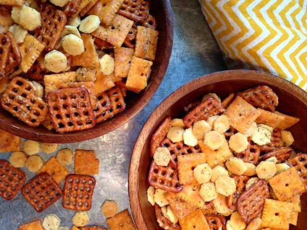 three bowls filled with cheetos and nuts on top of a blue table cloth