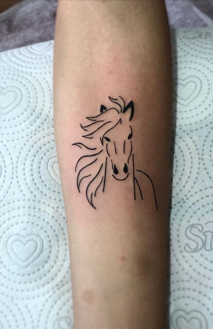 a small horse tattoo on the left forearm and leg, with a black outline of a horse's head