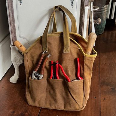 a canvas bag with tools in it sitting on the floor next to a door frame