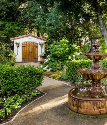 an outdoor fountain in the middle of a garden