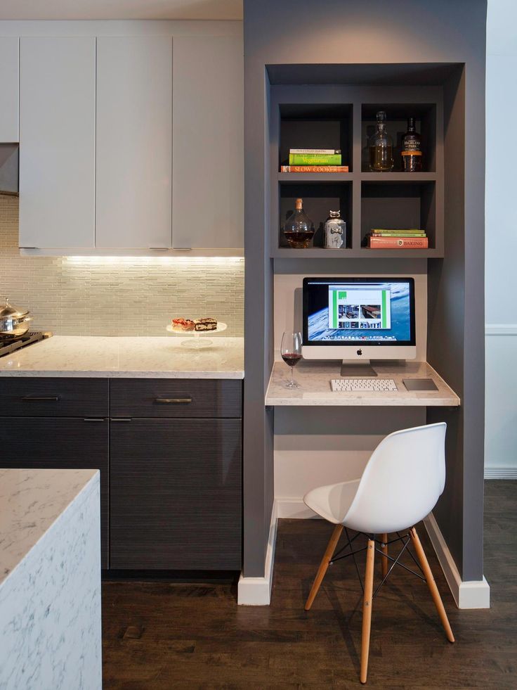 a desk with a computer on top of it in a kitchen next to a counter