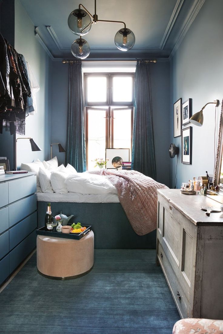 a bedroom with blue walls and furniture in it