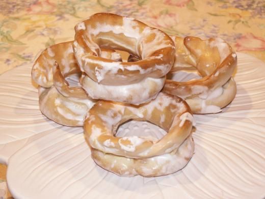 several donuts stacked on top of each other on a white plate with floral designs