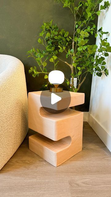 a plant sitting on top of a wooden box next to a couch