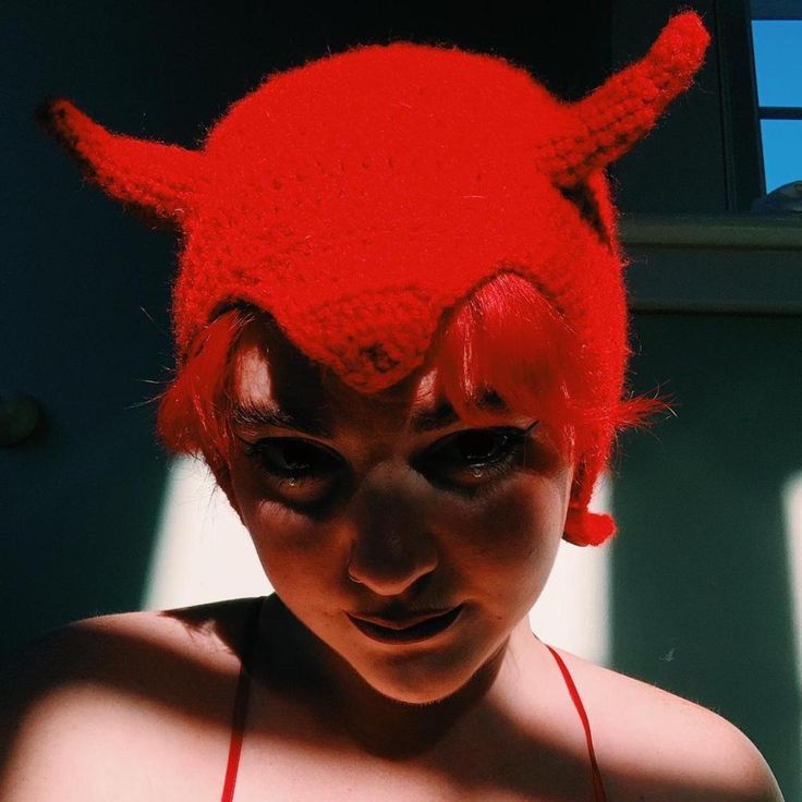 a woman with red hair and horns on her head