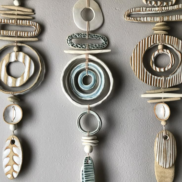 several decorative objects hanging on a wall in a row, with circular and oval shapes