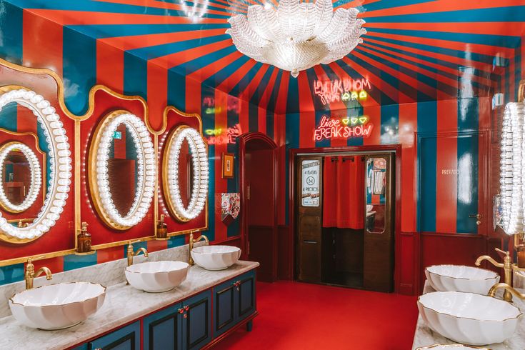 a bathroom with red, blue and white stripes on the walls is pictured in this image