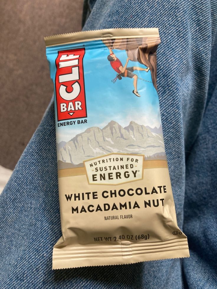 a bag of white chocolate macadamia nut energy bar sitting on someone's lap