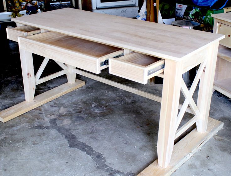 a wooden desk with two drawers on it in a room filled with other furniture and tools