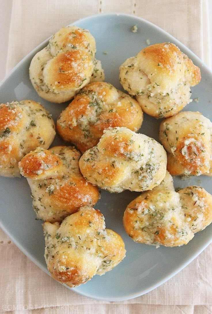 a blue plate topped with mini muffins covered in cheese