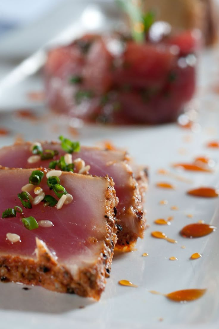 two pieces of food on a plate with sauces and garnishes around them