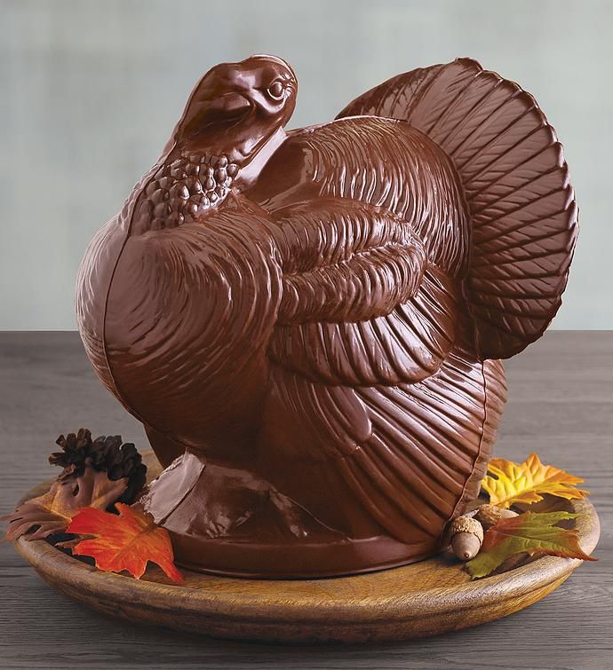 a chocolate turkey sitting on top of a wooden plate