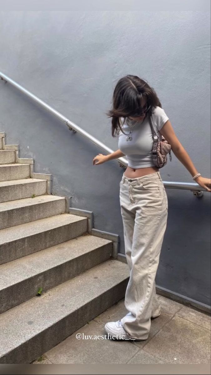 a woman walking up some stairs with her hand on the railing