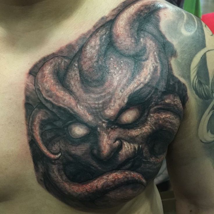 a close up of a man's chest with an octopus tattoo on his chest