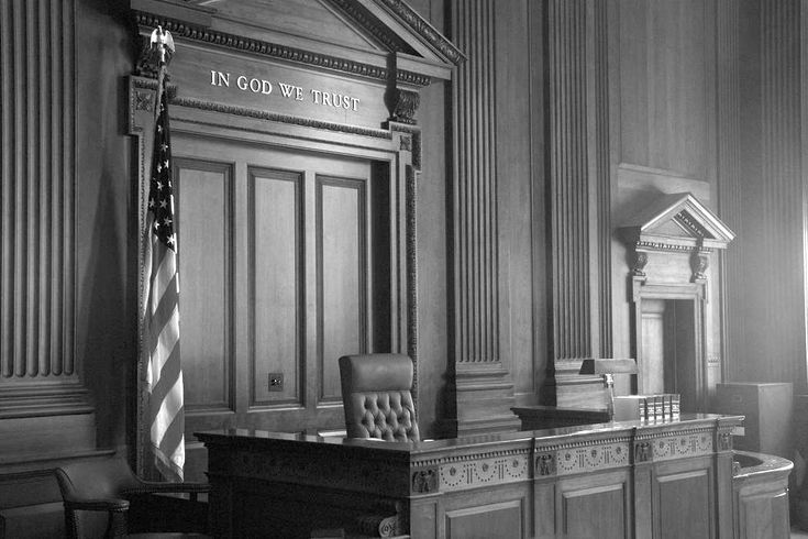 an empty courtroom with chairs and a flag on the desk in front of two doors