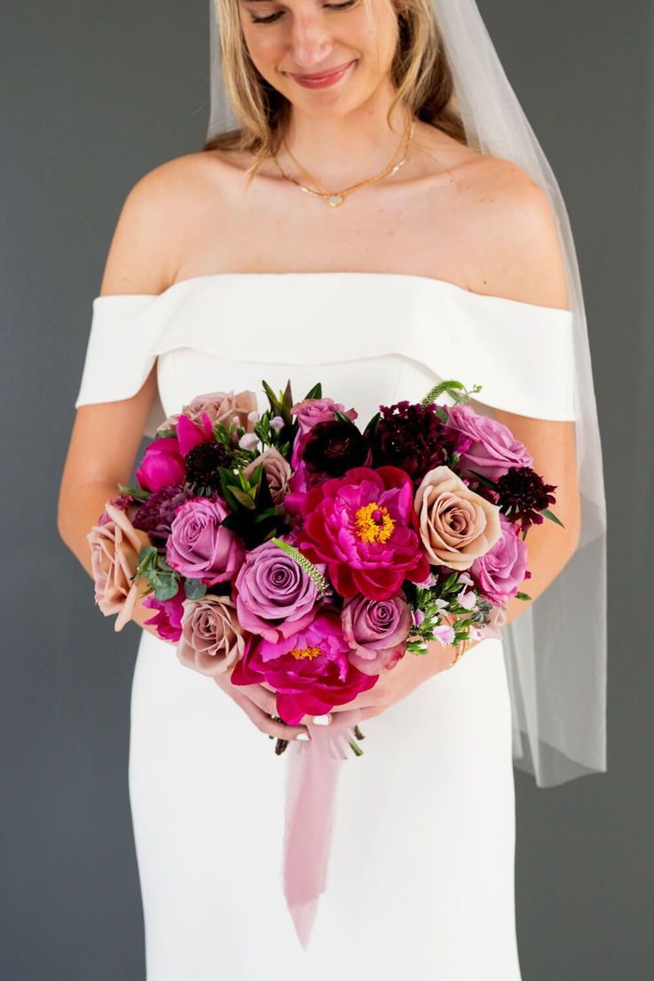 a woman holding a bouquet of flowers in her hands