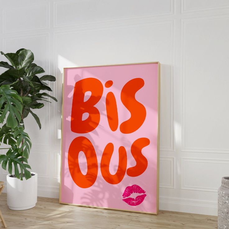 a pink poster with the words biss ous on it next to a potted plant