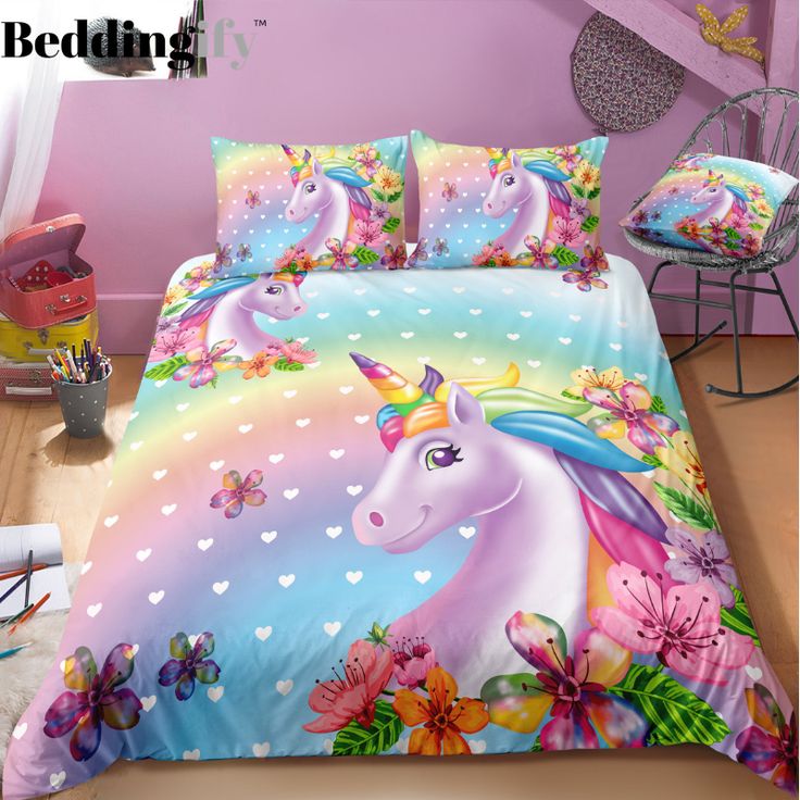 a unicorn bed set with colorful flowers and butterflies on the comforter, in a pink room