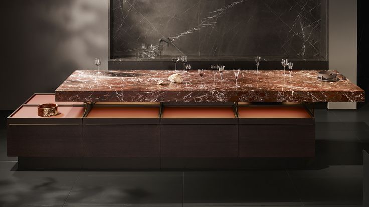 a marble table with two sinks in front of a black framed painting on the wall