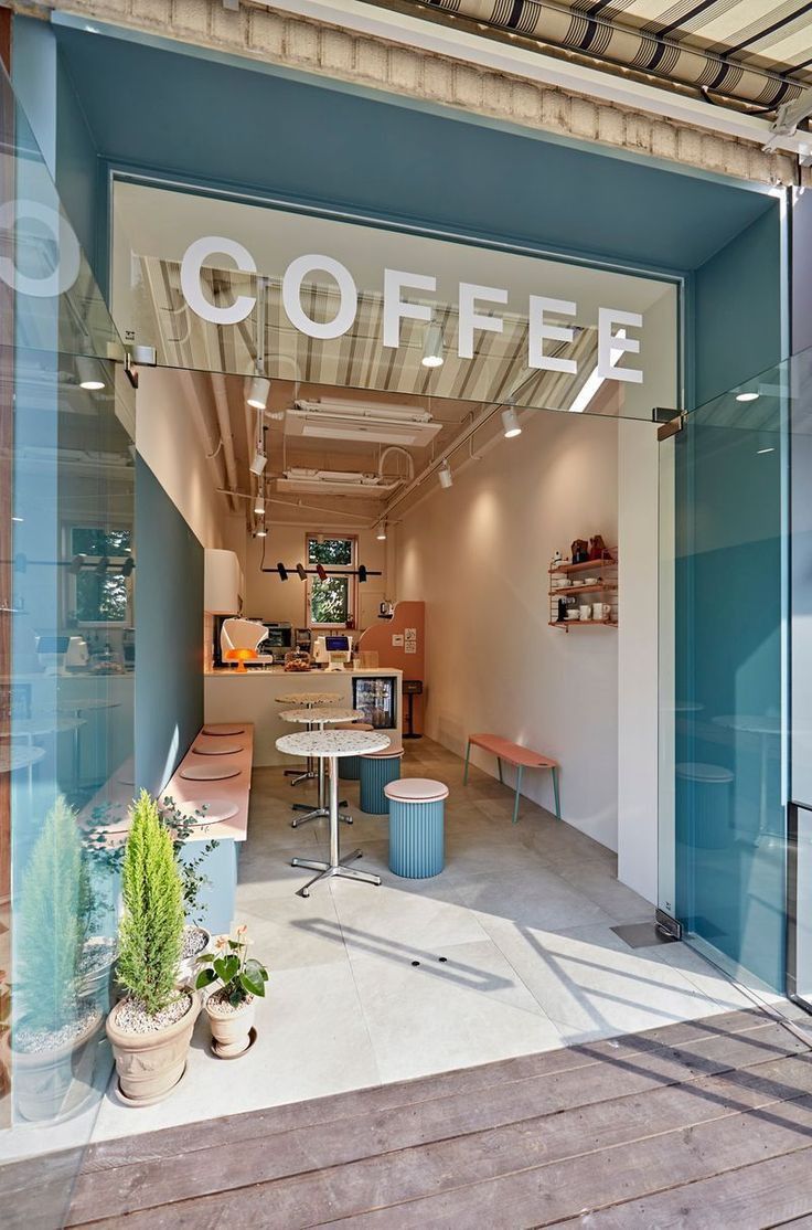 the inside of a coffee shop with blue walls and glass doors that says coffee on it