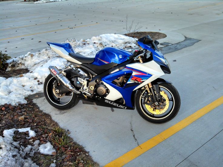 a blue and white motorcycle is parked on the side of the road in the snow