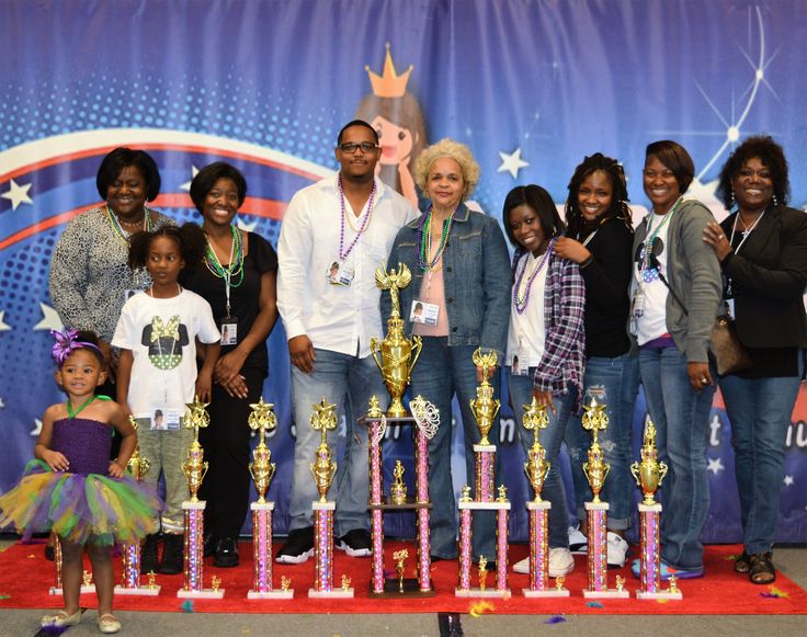 a group of people posing for a photo with trophies