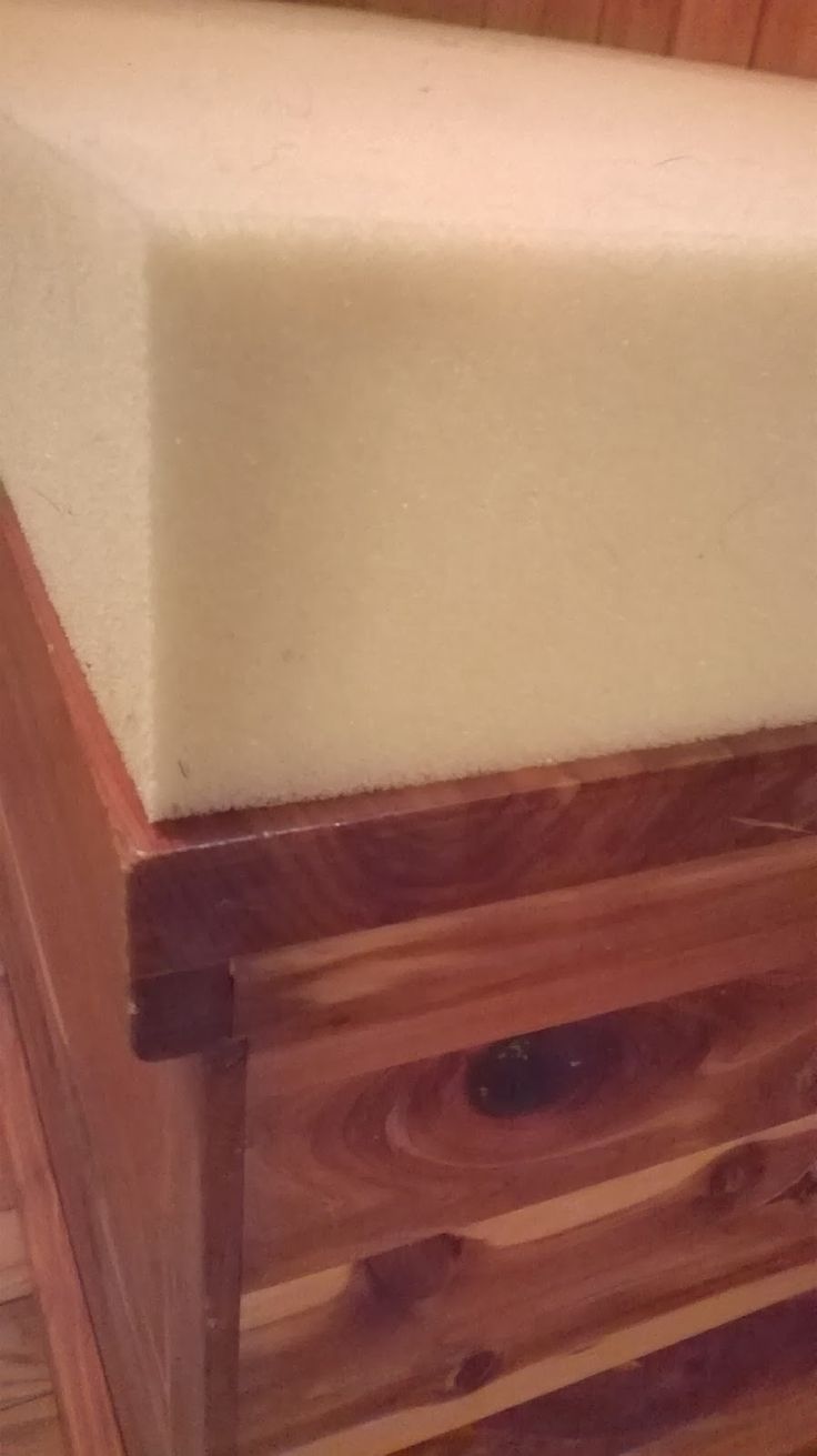 a close up of a wooden box with a mattress on the top and bottom part