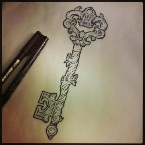 a drawing of a key on paper next to a pen and ink roller with an intricate design