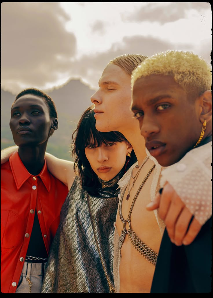 four young men standing next to each other with their arms around one another and looking up at the sky