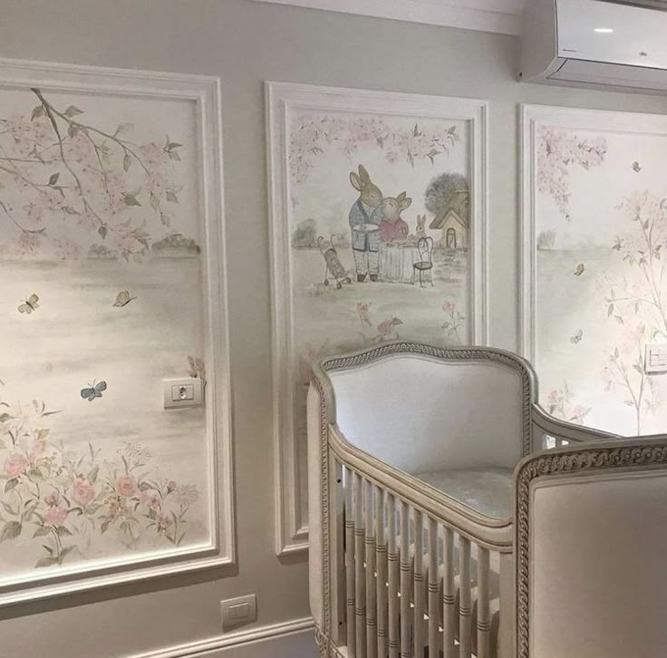 a baby crib in the corner of a room with paintings on the wall behind it