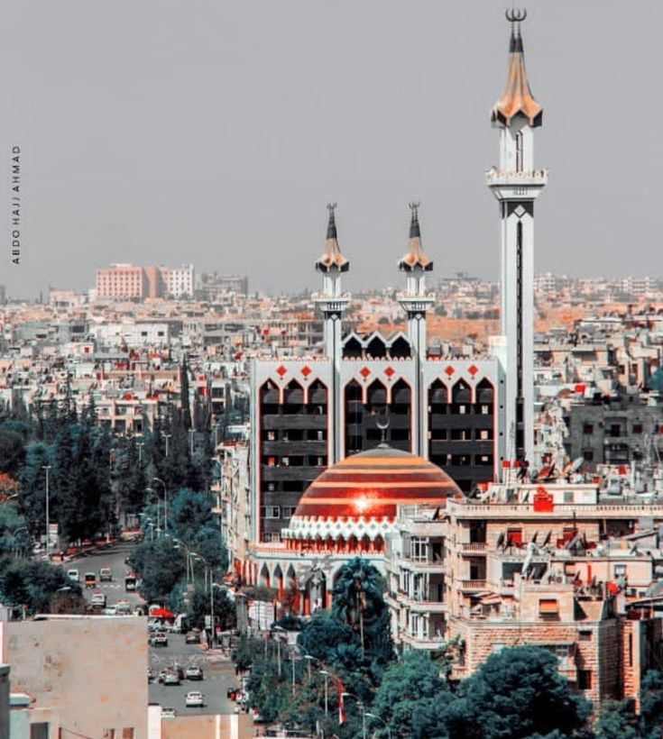 an aerial view of a city with many tall buildings and spires in the background