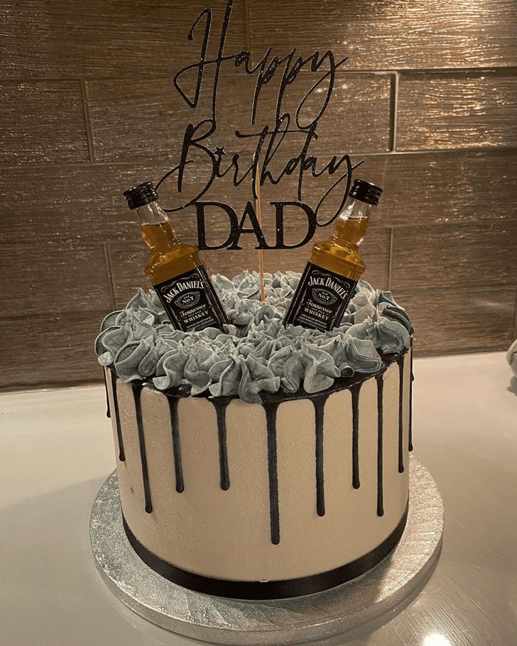 a birthday cake with two bottles of whiskey on top and the words happy birthday dad