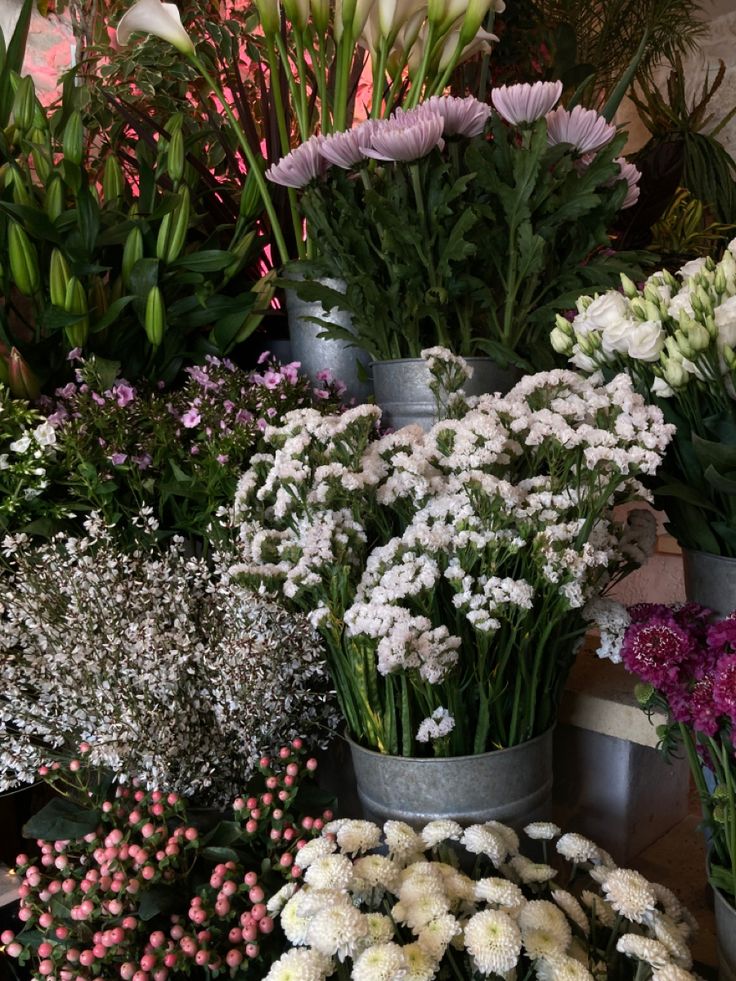 many different types of flowers in buckets