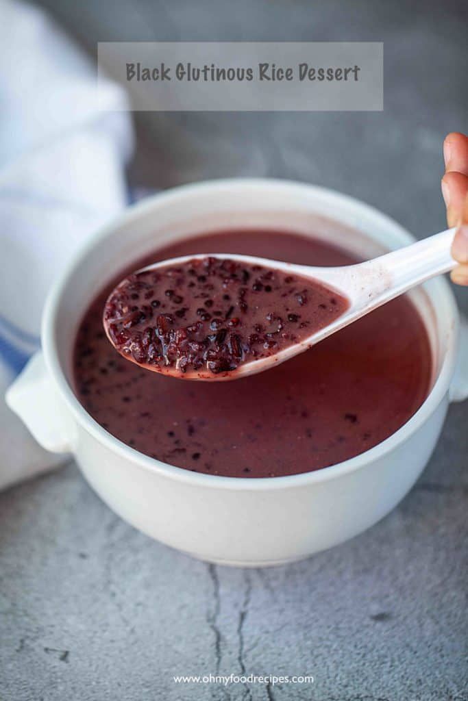 a spoon full of red soup with cranberries in it and text overlay reading black glorious rice dessert