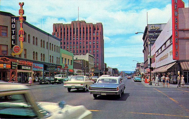 an old photo of cars driving down the street