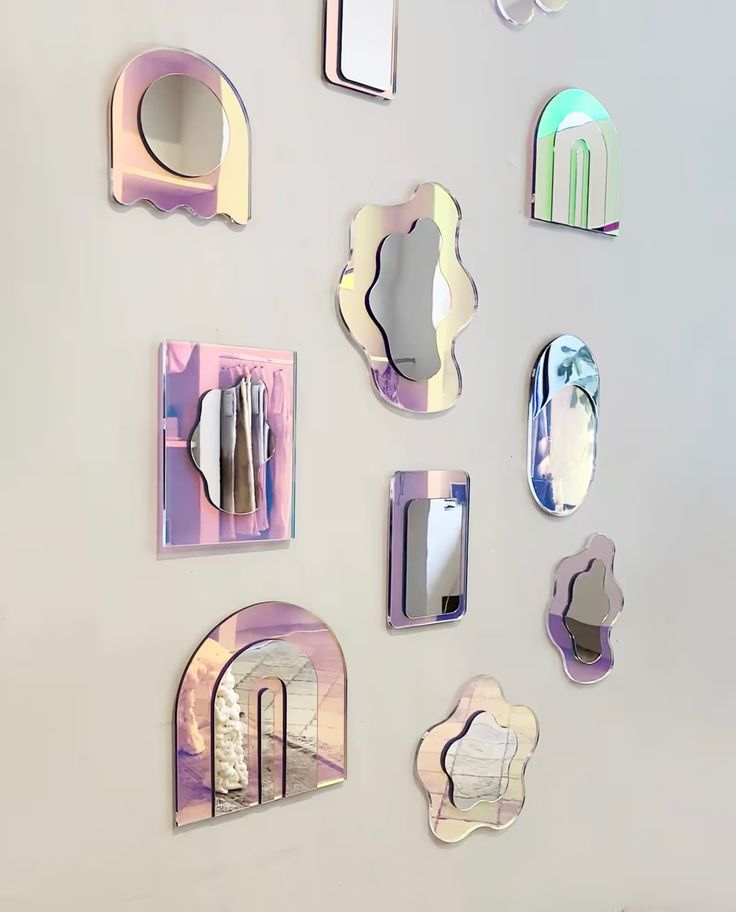 there are many mirrors on the wall and one is reflecting them in different shapes, sizes and colors