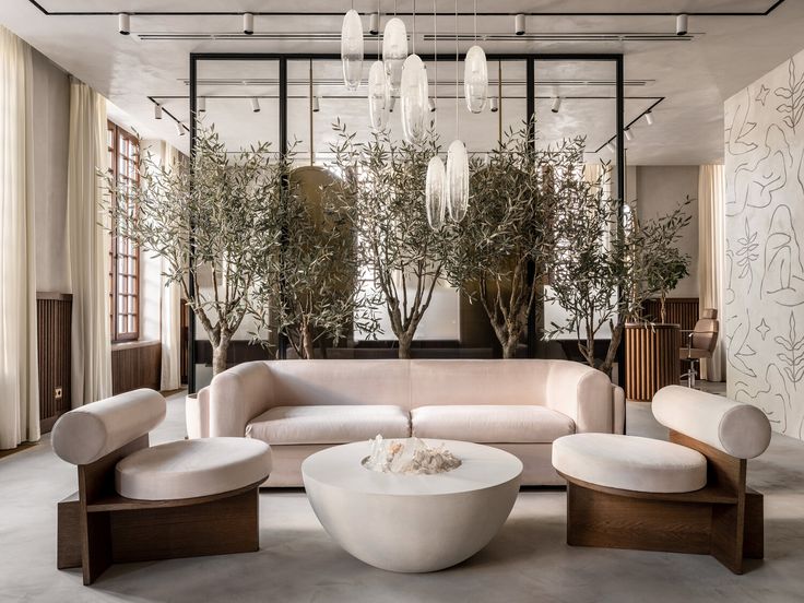 an elegant living room with white furniture and chandelier hanging from the ceiling above