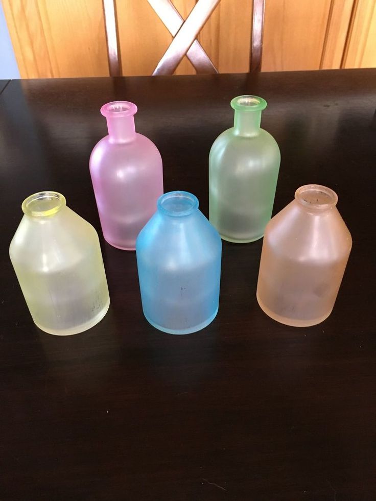 six small glass bottles sitting on top of a wooden table