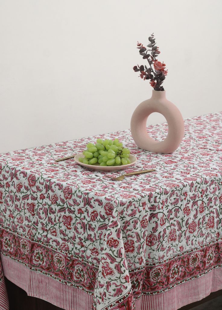 a bowl of grapes sits on top of a table