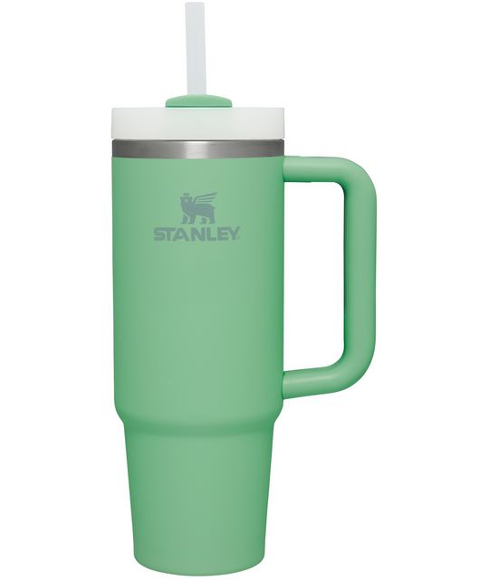 a green travel mug with a white lid and handle on the side that says stanley