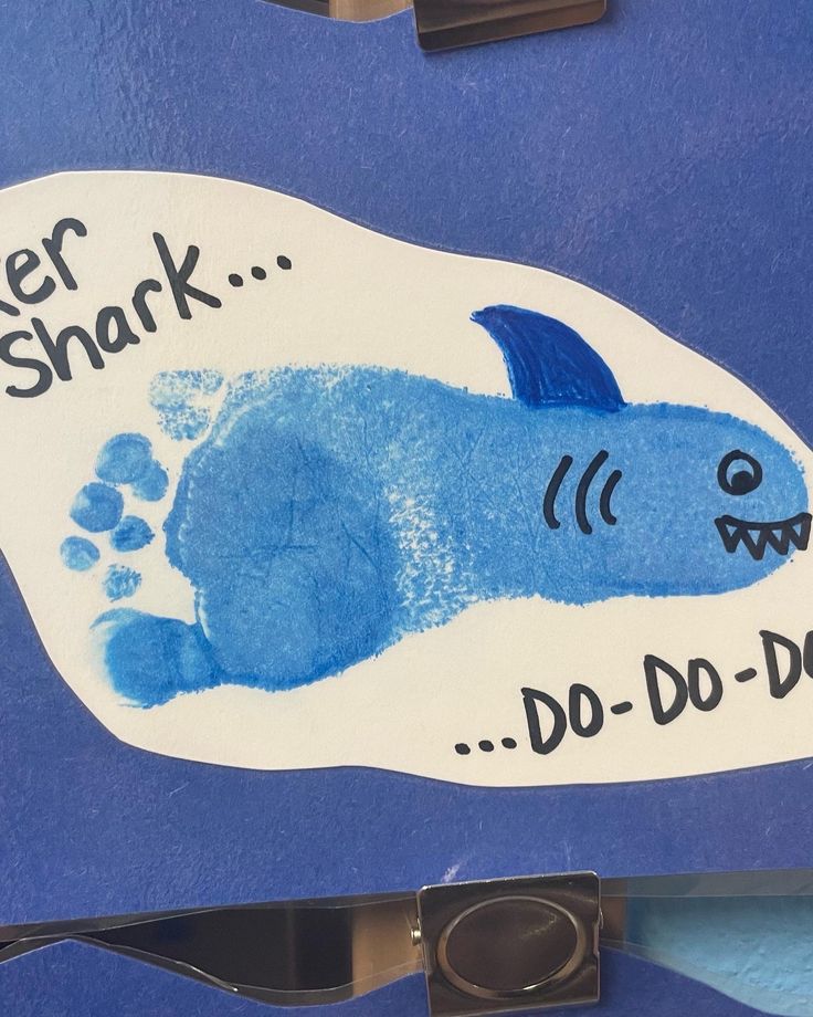 a blue and white sign with a shark drawn on it