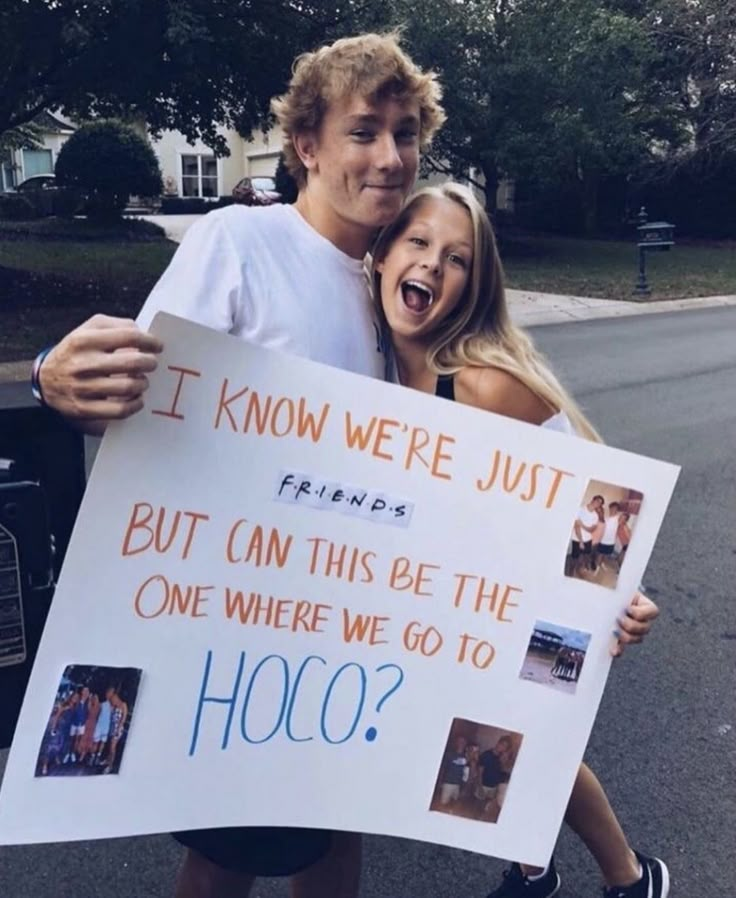 a man and woman holding a sign that says it know we're just friends but can this be the one where we go to hoo?