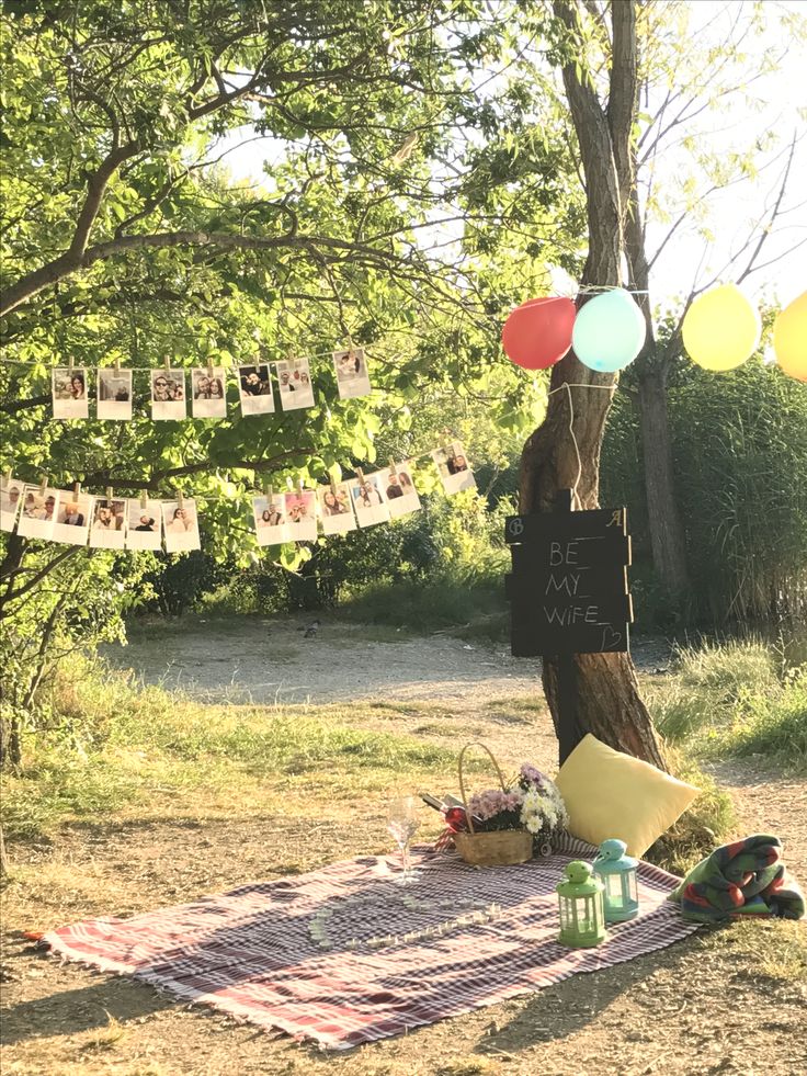 a picnic with balloons and pictures hanging from the trees