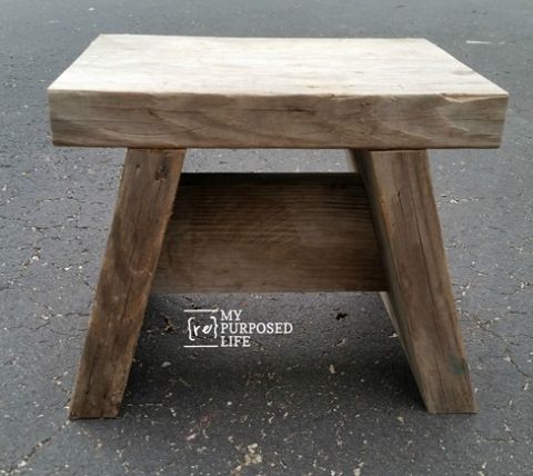 a wooden stool sitting on top of a cement ground