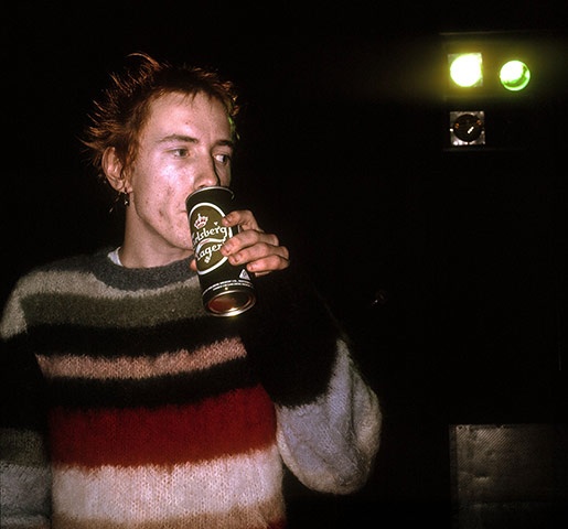 a man drinking from a can in the dark