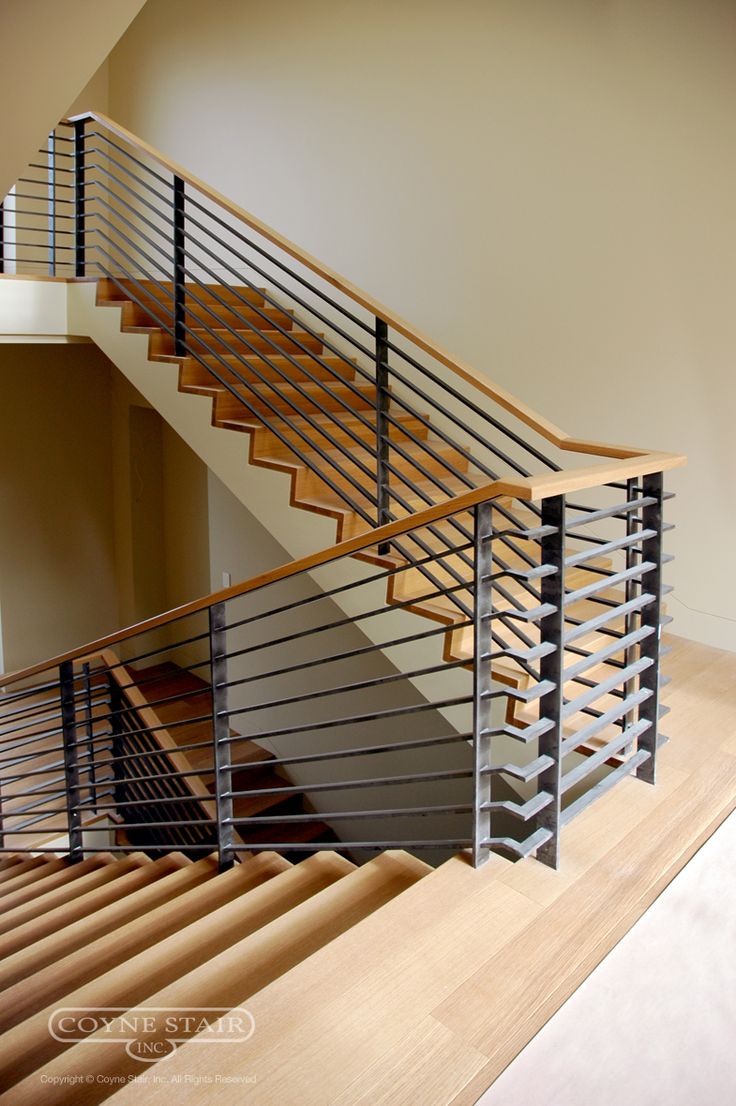 a wooden stair case with metal handrails