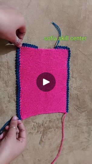 someone is crocheting a pink square on the floor with scissors and yarn in it