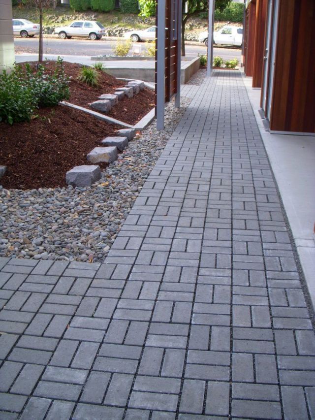 the sidewalk is lined with stones and gravel