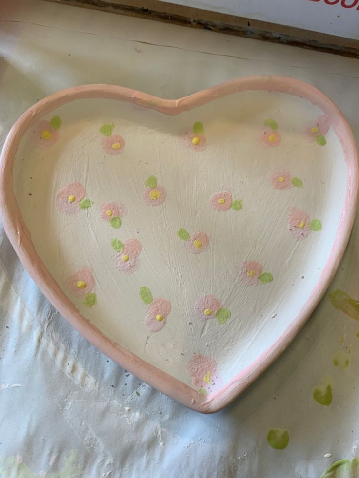 a heart shaped dish sitting on top of a table