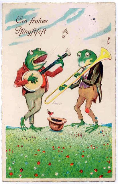 two frogs are playing musical instruments in the grass, and one frog is holding a trombone